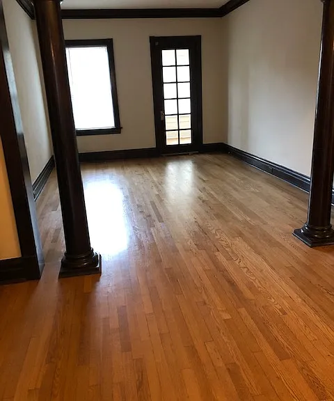 Columned living room with French door to sunroom