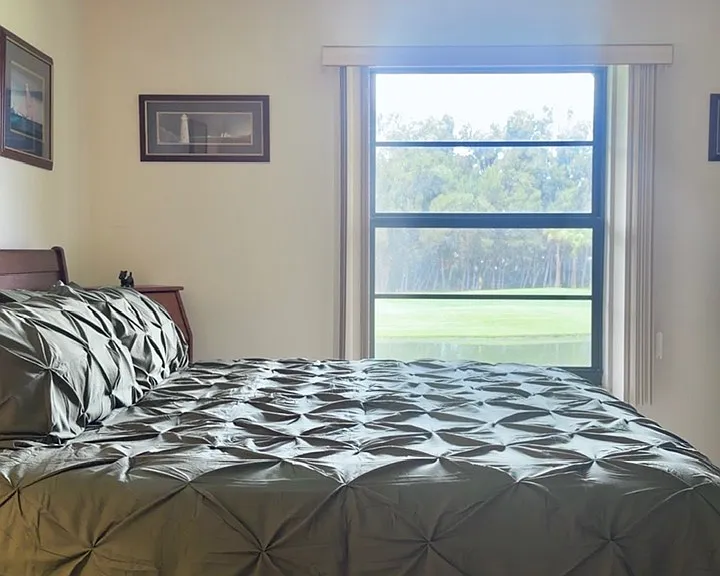 Primary bedroom w/ stunning lake & golf course views