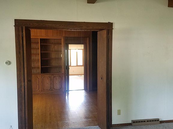 Looking through double doors from living room to library room to kitchen
