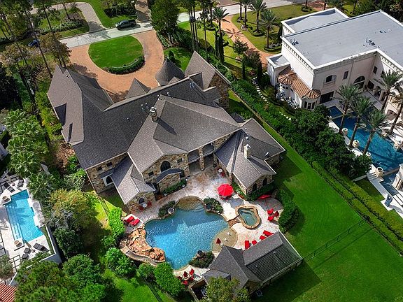 This overhead view of the home shows the serenity of the rear grounds with an enormous pool, slide, waterfall, and spa!