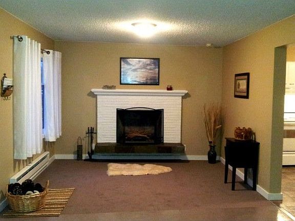 Large Living Room with Brick & Slate Wood Burning Fireplace. All New Carpet, Paint, Light Fixtures &