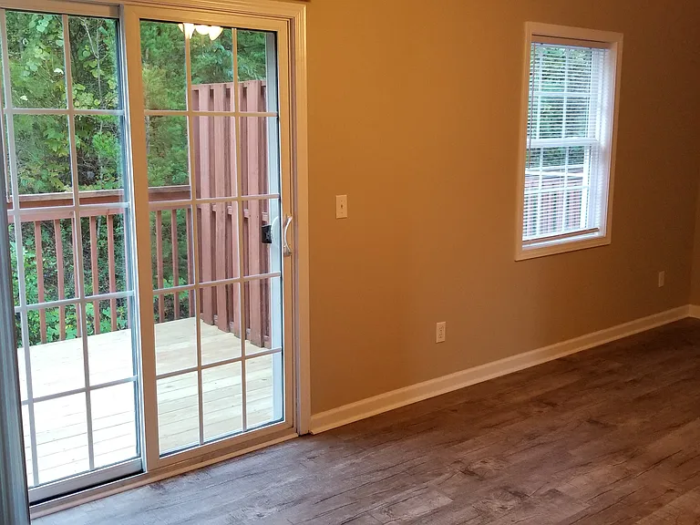 MASTER BEDROOM WITH PRIVATE BACK DECK OVER TOP GROUND LEVEL CONCRETE PATIO