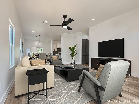 Living room area open to the dining and kitchen area (virtual staging)
