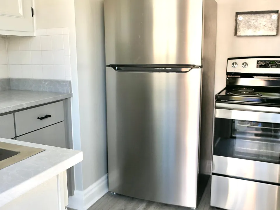 Kitchen with new stainless steel fridge & stove, new flooring, cabinetry and countertops