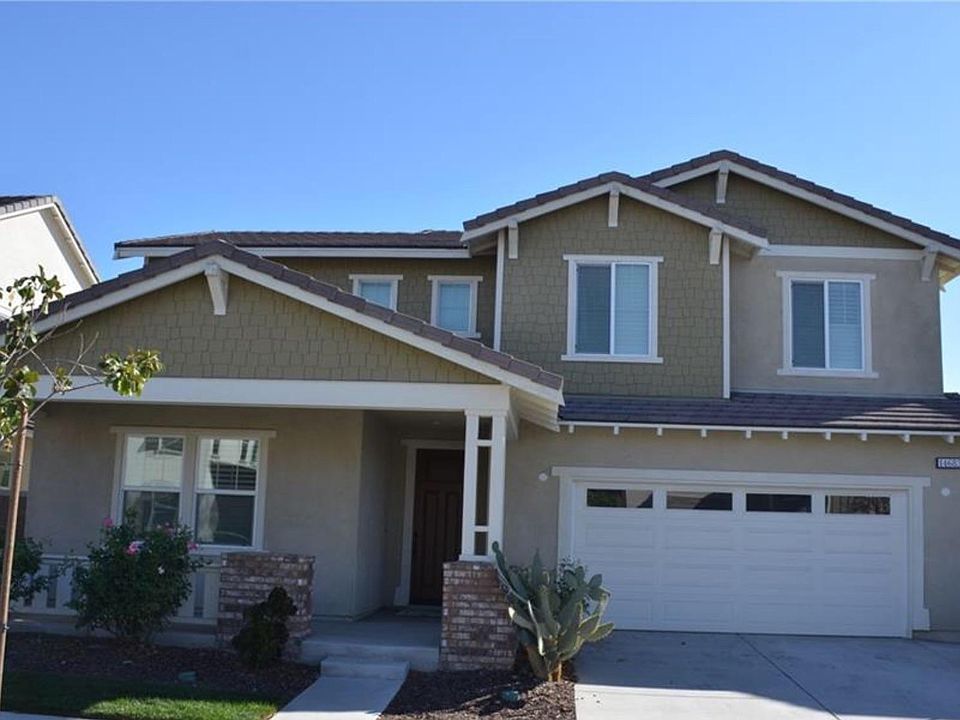 Front of the property with patio, two door garage, and drive