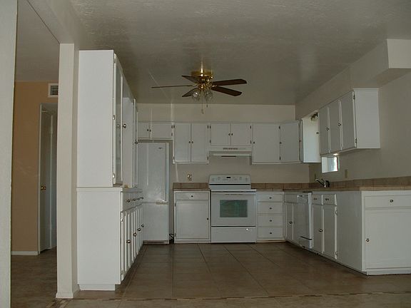 Large Kitchen with Tiled Counters & plenty of Cabinets Space and Drawers.