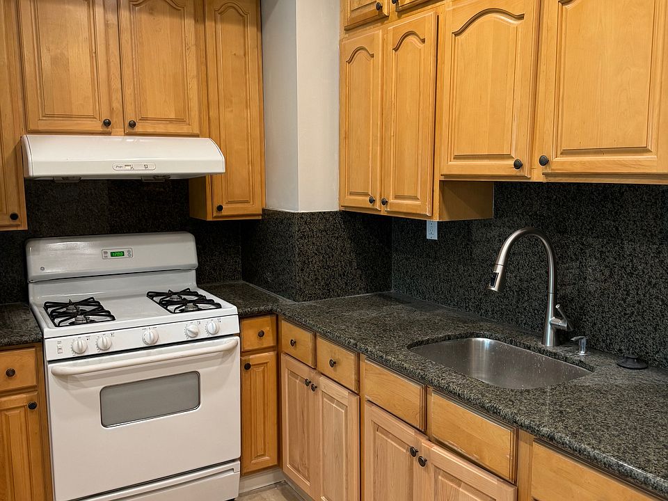 kitchen with granite counter, gas stove, plenty of storage cabinet space