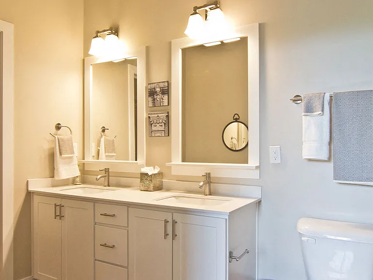 Marble countertops with undermount sinks and framed vanity mirrors