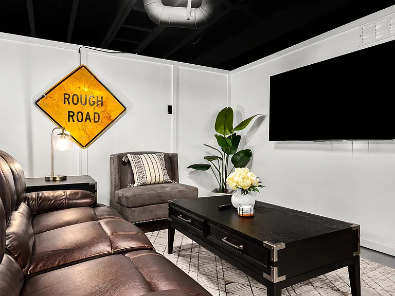 The plush couch and the soft lighting create a relaxing atmosphere, while the coffee table is the perfect place to set down drinks and snacks.