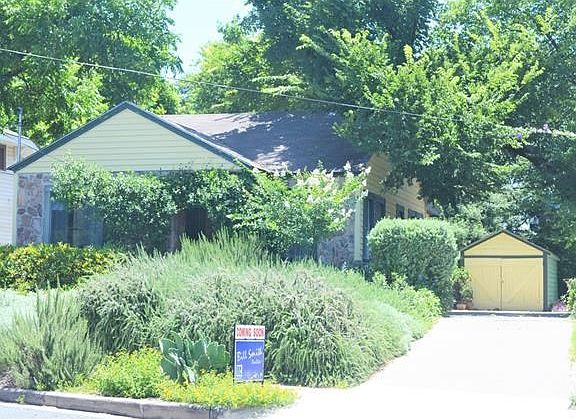 Lush, low maintenance yard offers some shade and relief from heat with private drive to garage.