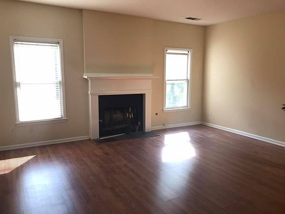 Living room with fireplace and newly installed flooring.