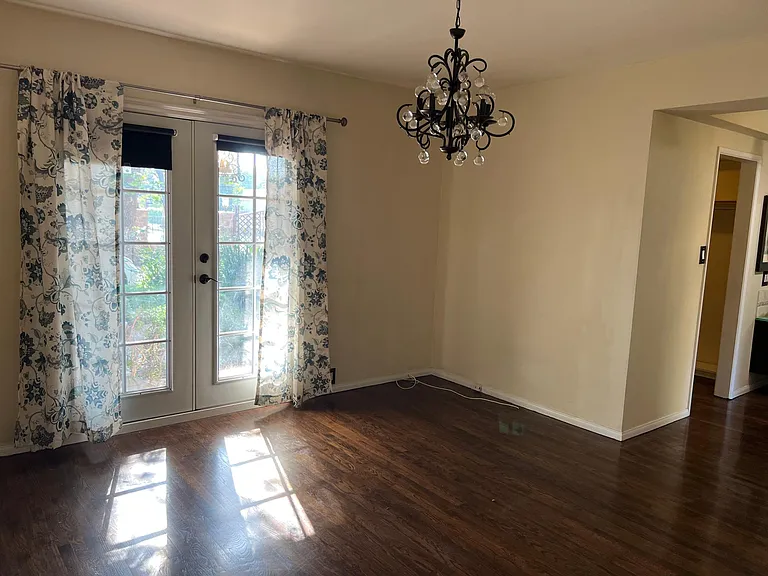Master bedroom with original wood floors and chandelier.