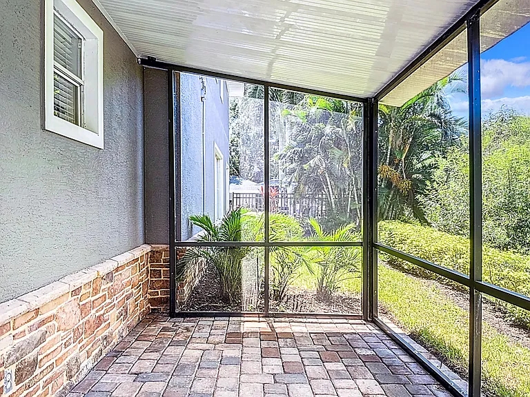 Enjoy the tranquil view from your private screened-in patio offering a perfect spot to unwind.
