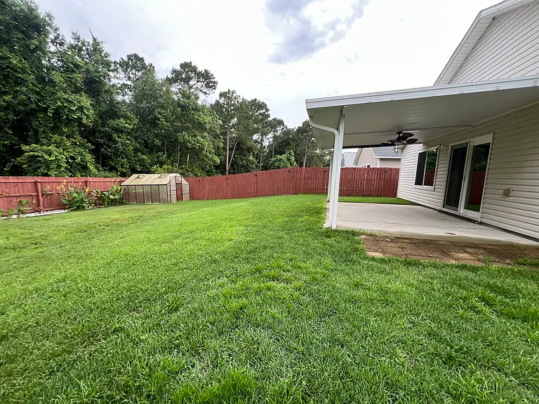 Back yard side view with green house