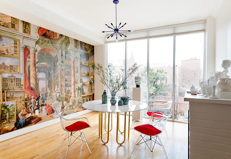One wall is a luxe mural based on a 1757 painting in the MET. Another wall is floor to ceiling glass. The table is Adler.
