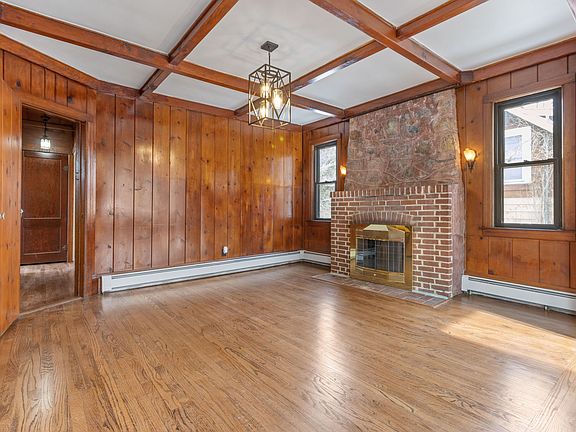 Living room with wood burning fireplace and ample sunlight