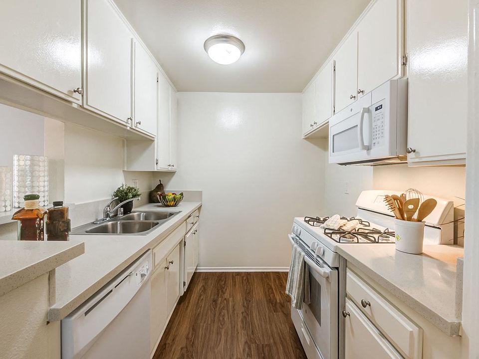 Spacious and modern kitchen with plank flooring at the Plaza Apartments in Sherman Village