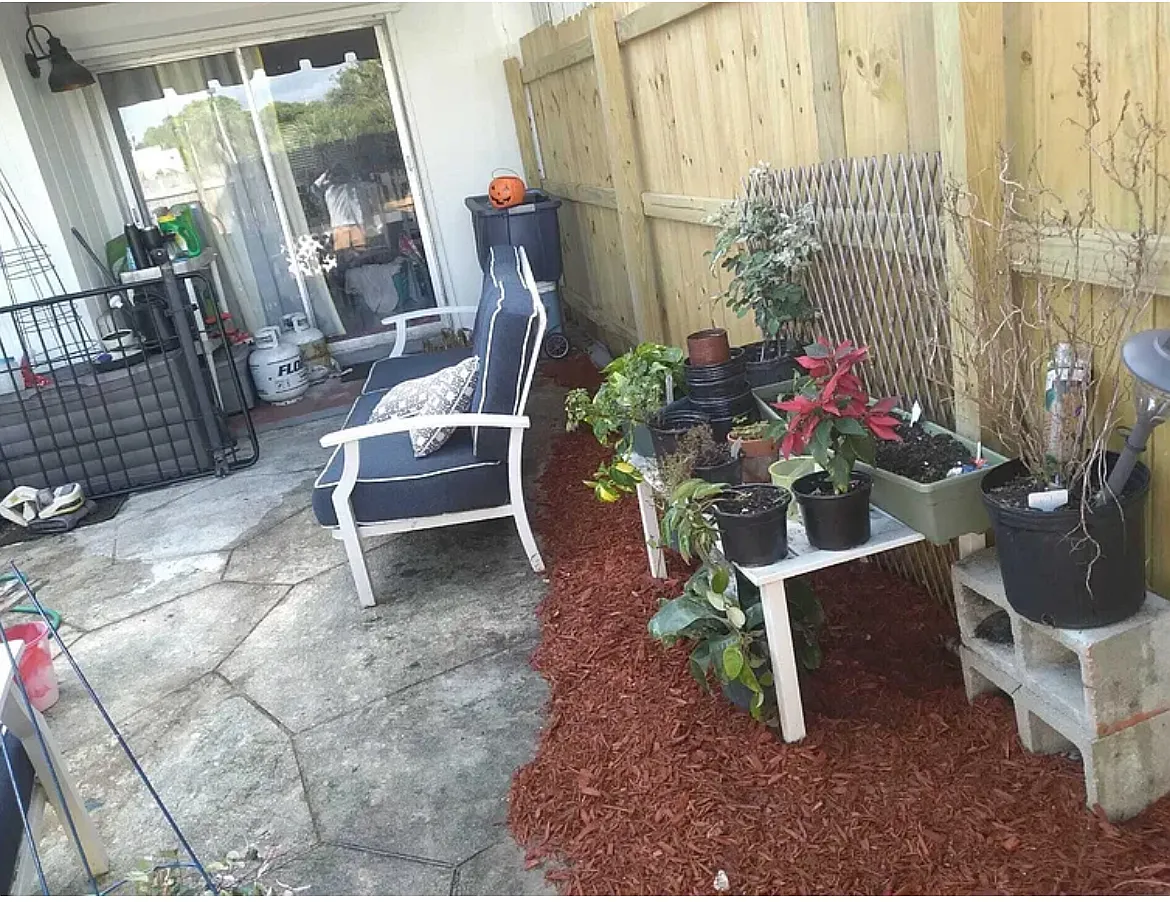 The backyard at 3609 Townhouse Ct, West Palm Beach, FL 33407, offers a private, fenced oasis ideal for outdoor dining, gardening, or relaxation. Residents can enjoy tranquil lake views directly from the backyard, enhancing the serene ambiance. - 3609 Townhouse Ct