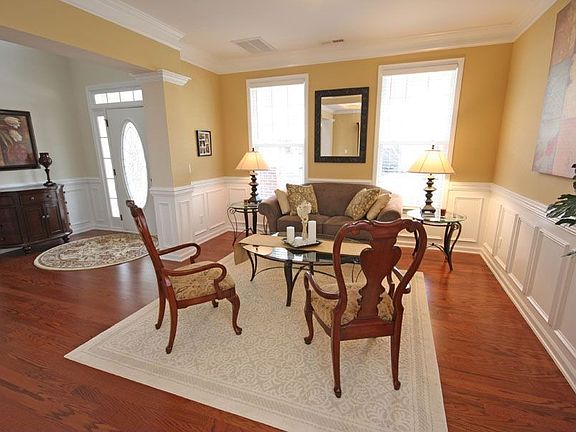 Formal living room boasts judges paneling, crown molding and hardwoods.