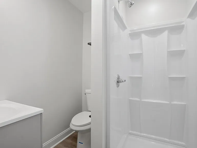 Full bathroom with a tub/shower combo, built-in shower shelving, and a vanity with sink for daily convenience.