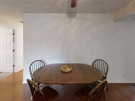 Dining Room with laminate flooring and ceiling fan is open to the family room with French doors to covered patio.