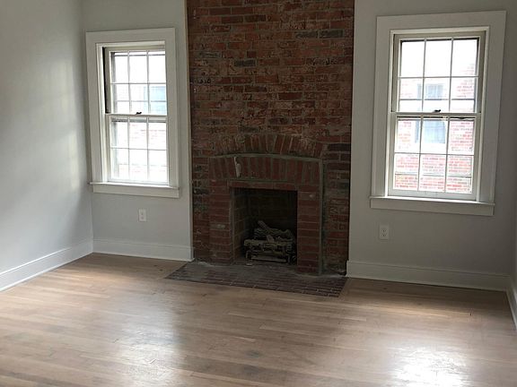 Great natural light through this space. There is now a mantle on attached to this exposed brick fireplace. The fireplace isn't usable, but it's wonderful for ambiance.