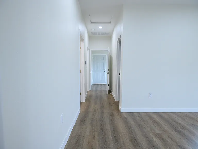 Hallway to 2nd, 3rd bedroom, bathroom (right) and landury room (end)