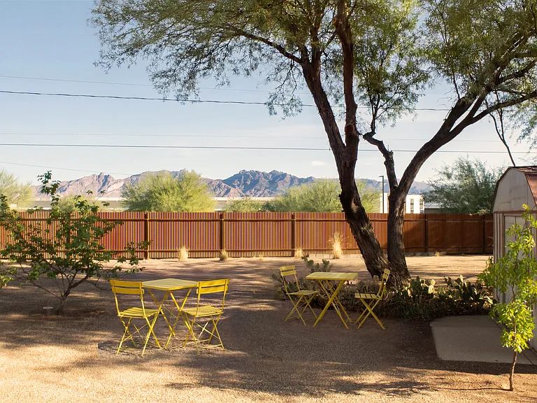 Private fenced backyard with shaded seating and mountain views.