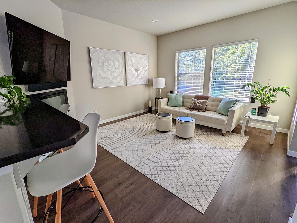 Bright living area with large windows and open flow from the kitchen.