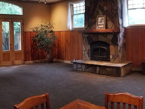 The Main Living Area - wood burning fireplace, 11' ceiling with fan, french doors exiting to private and shady courtyard, high windows with lots of natural light, and originally wainscoting.