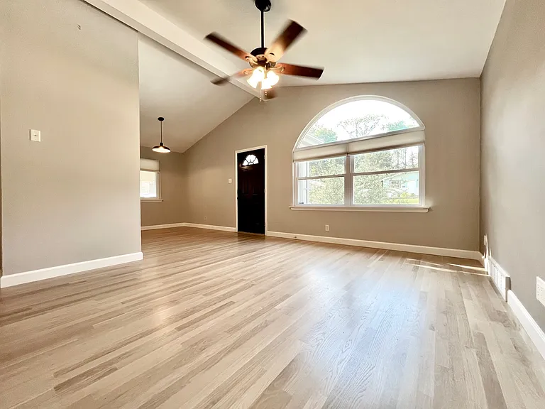 Living room into dining room. Vaulted ceilings and brand new white oak hardwood.
