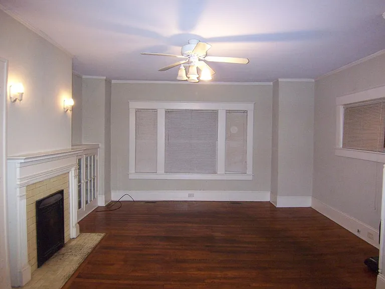 Living room w/ fireplace on left with glass door cabinet to