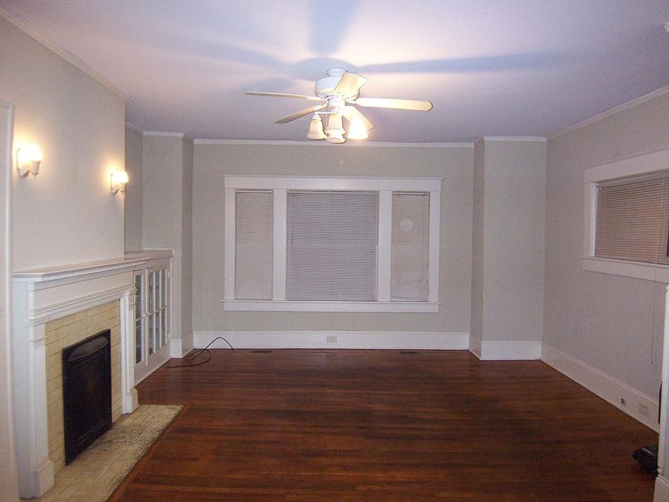 Living room w/ fireplace on left with glass door cabinet to