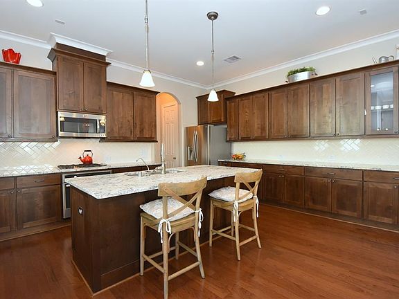 Over-sized kitchen has granite counters, custom cabinetry with raised panel doors and elegant crown moulding, ceramic tile backsplash, and stainless appliances. First floor is pre-wired for surround sound.