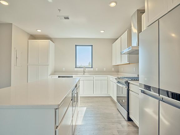 Kitchen with gas range large island and two pantry cabinets.
