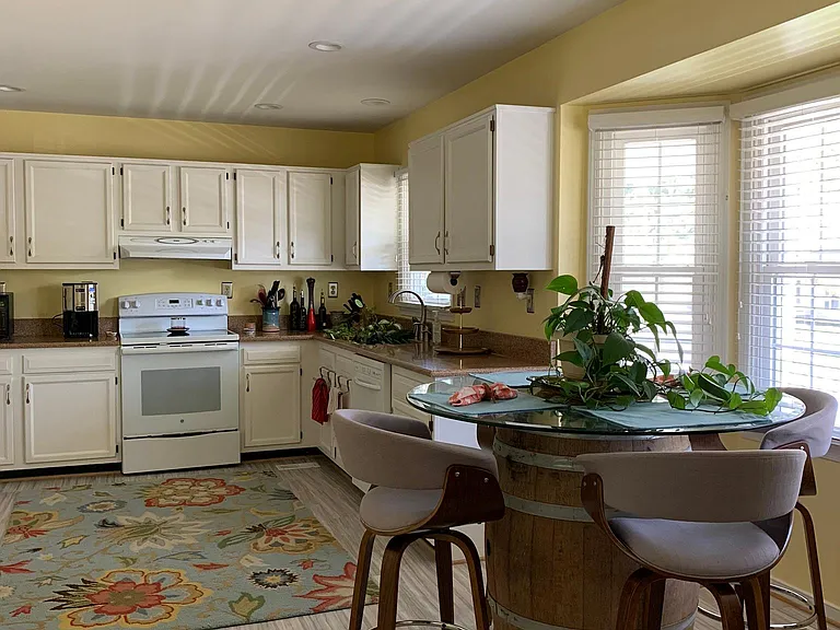 Comfortable kitchen with eat-in area. Flooring has been renovated with hardwood floor and walls repainted to a neutral color (see next photo).