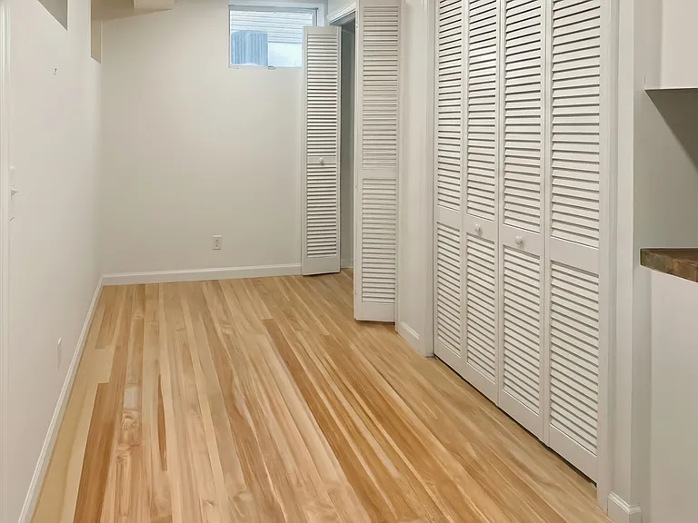Hallway closet and storage area with updated flooring and easy access to laundry.