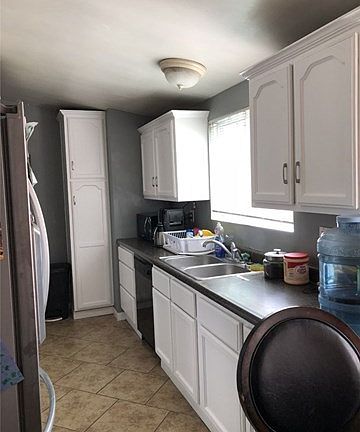 Kitchen with white cabinets and tiled floor
