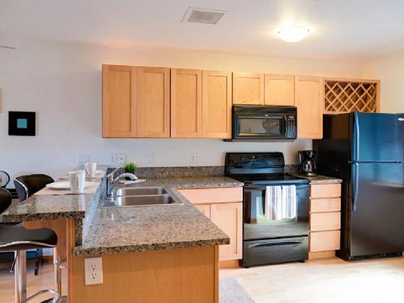 Kitchen with granite counter & stainless steel appliances.