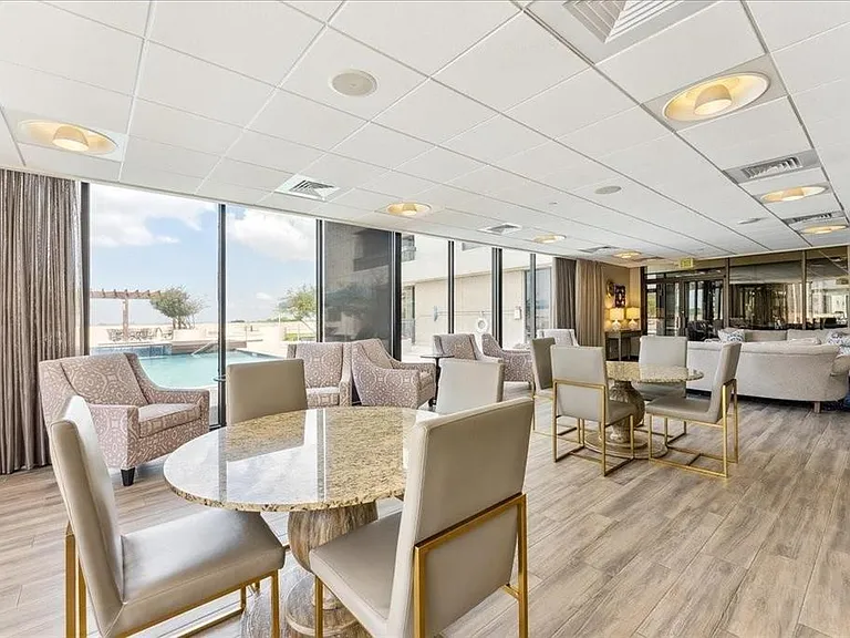Expansive common area featuring floor-to-ceiling windows, wood-finish flooring, and recessed ceiling lighting