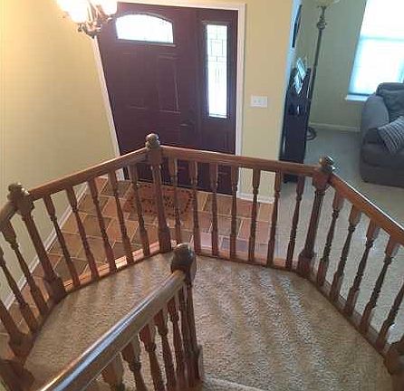 Entry. This tile floored entry and beautiful curved staircase are open to the living room.