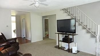 Attractive and welcoming living room with open stairway up.