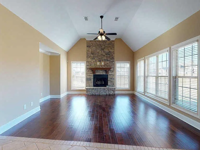 Main level Family room off kitchen area with gas stone fireplace and abundant windows