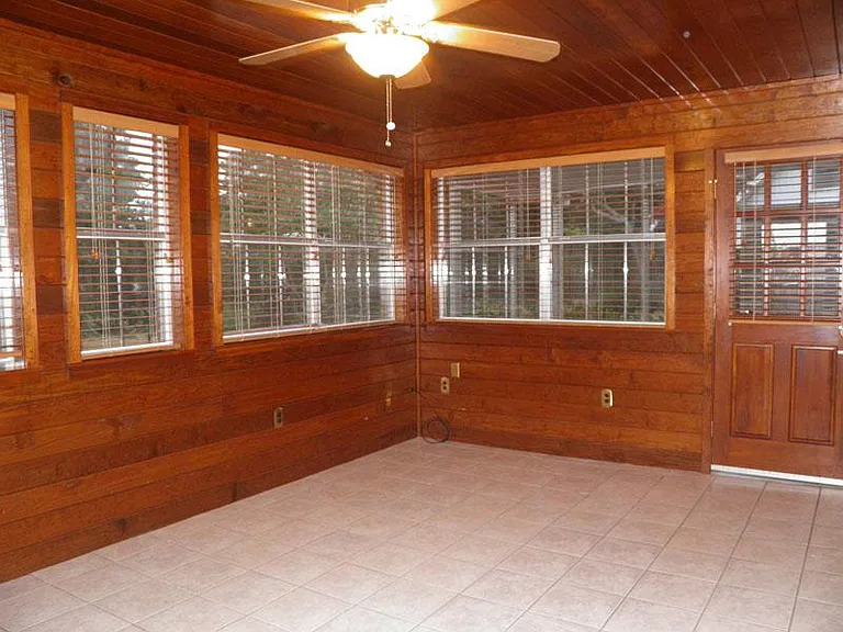 Sunroom exits to screened in porch. Exquisite hard pine, tongue and groove boards walls and ceiling give a farmhouse/rustic feel to this area. Fully tiled floors. Separate AC unit will cool this room more when needed during summer BBQ's and gatherings.