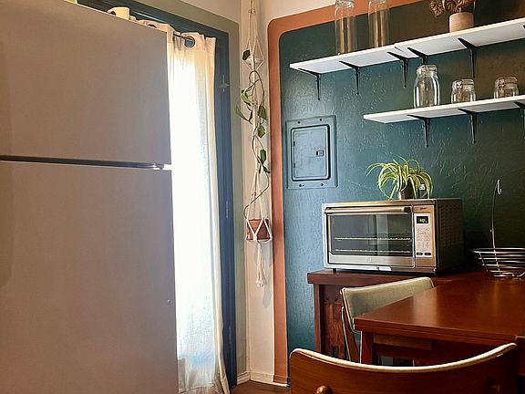 Kitchen and dining area. Includes toaster oven, toaster, rice cooker, microwave, hot pot, coffee maker, and full size fridge. Table can be extended or tucked away.