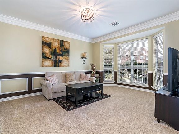 This is traditionally the dining room in this home, featuring a large bay window and chair rail, picture frame and crown moldings. Currently it is being used as an extra tv room for this family, but I can just imagine the elegant possibilities this r