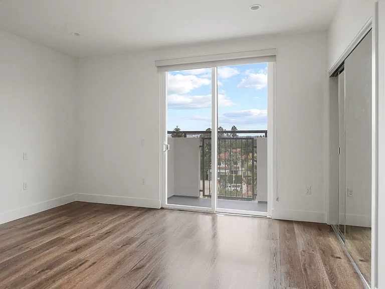 Bedroom with Mirrored Closet, Recessed Lighting, Vinyl Flooring, and Patio