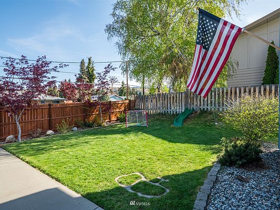 Fully fenced large front yard with green lawn