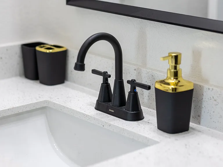 Guest Restroom sink with complimentary hand soak and toothbrush holder containers.