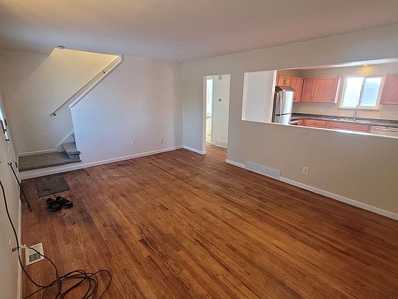 Living room with view of kitchen and stairway.